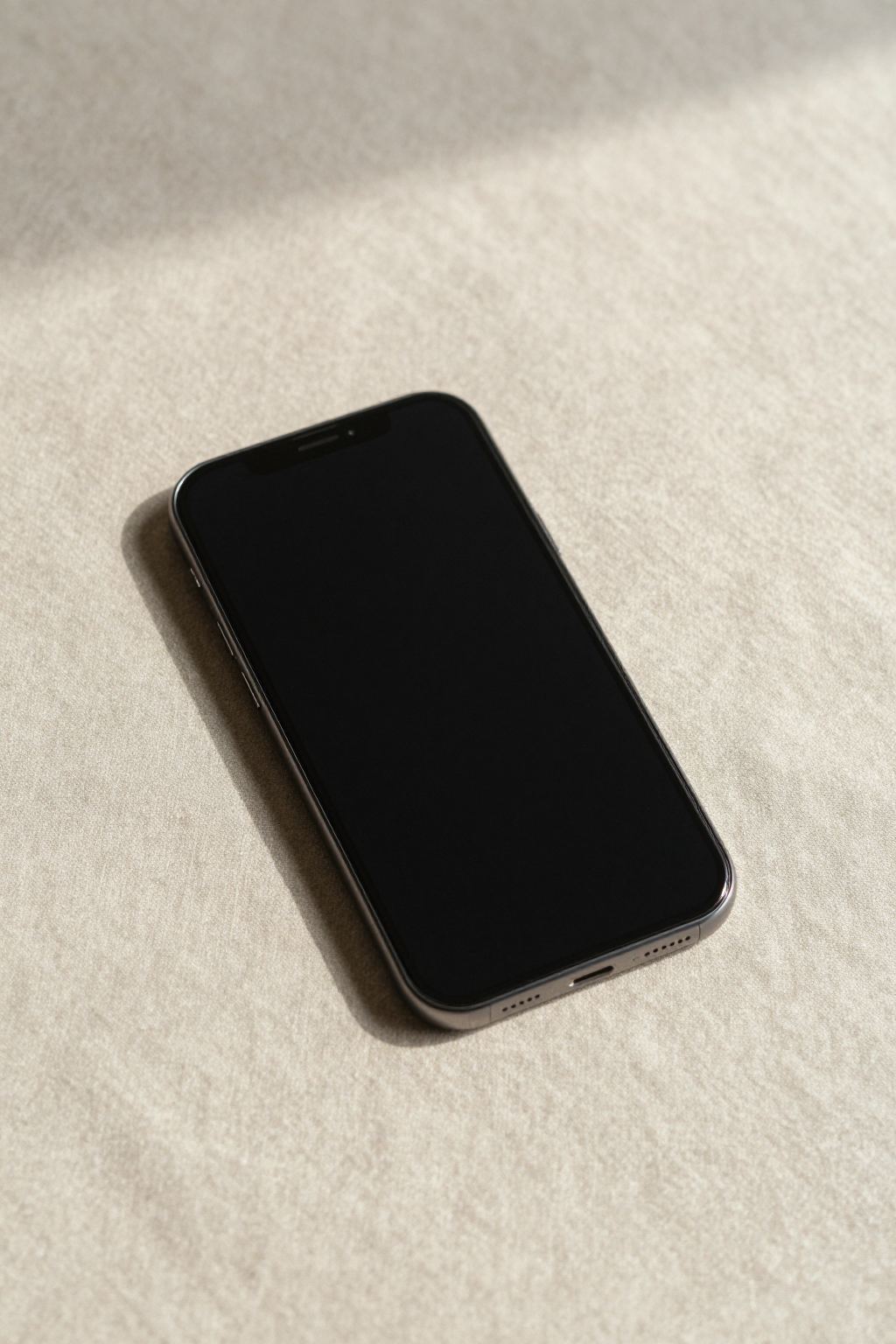 深い色のデスクに置かれたスマートフォン